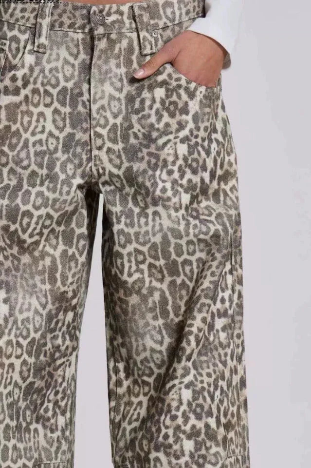 Close-up of the front of wide leg leopard print denim pants, showing pockets.