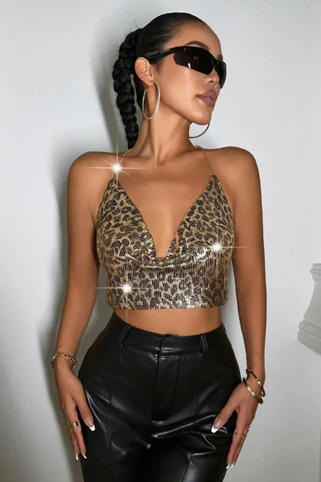 Close-up of a woman's torso wearing a gold leopard print sequined halter crop top