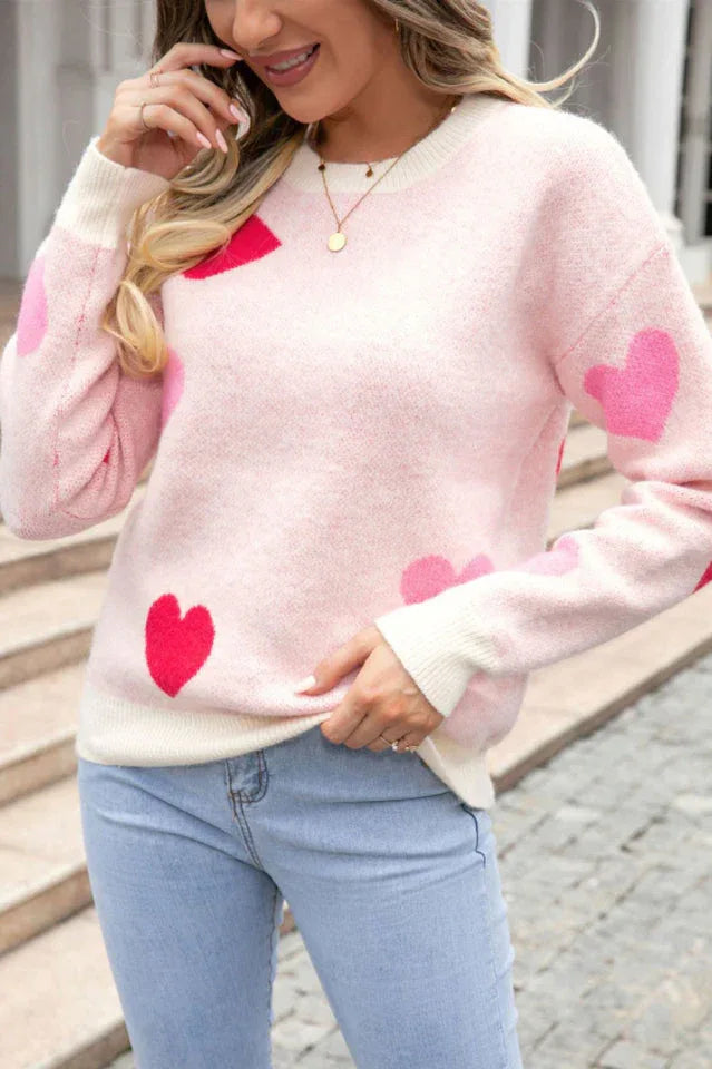 Close-up of a woman wearing a pink heart print sweater.