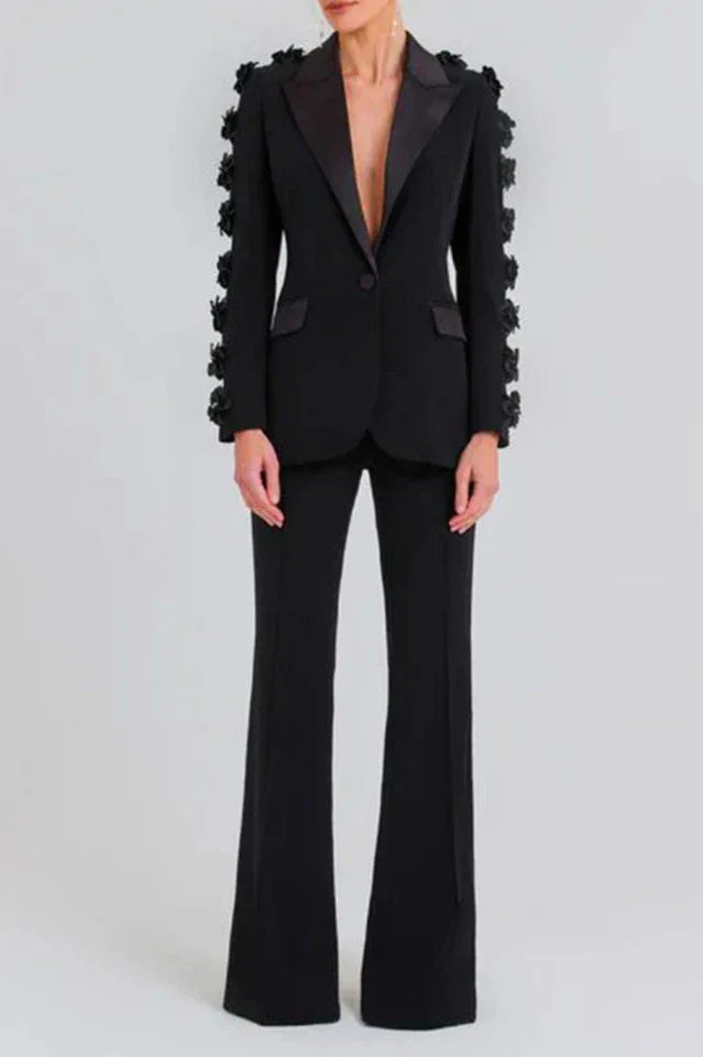 Full-body view of a woman in a black formal suit with flared trousers