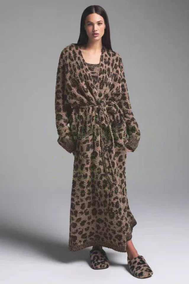 Woman wearing a leopard print fuzzy robe tied at the waist with slippers.
