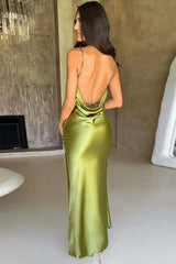 Back view of a woman wearing a long olive green satin slip dress with spaghetti straps and an open back.