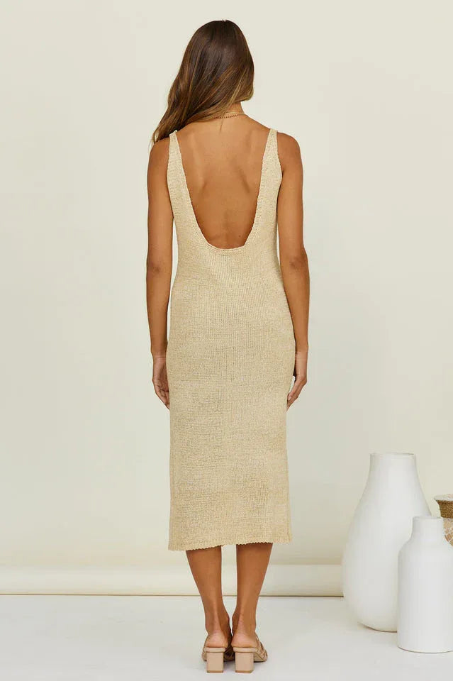 Back view of a woman in a beige knit midi dress with a deep scoop back