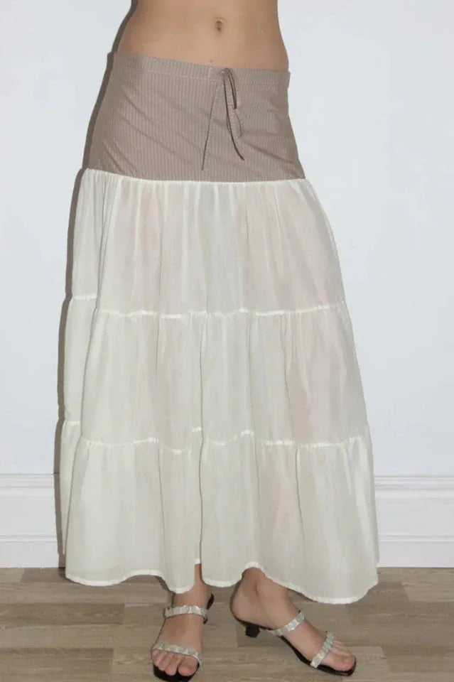 Close-up of the tiered maxi skirt with a brown pinstripe waistband, showing the fabric texture and details.