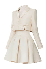 Product shot of the cream-colored cropped jacket and pleated skirt set