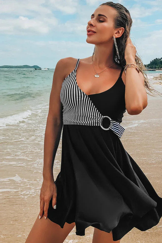 Woman wearing a royal blue swimdress with geometric pattern accent on a beach