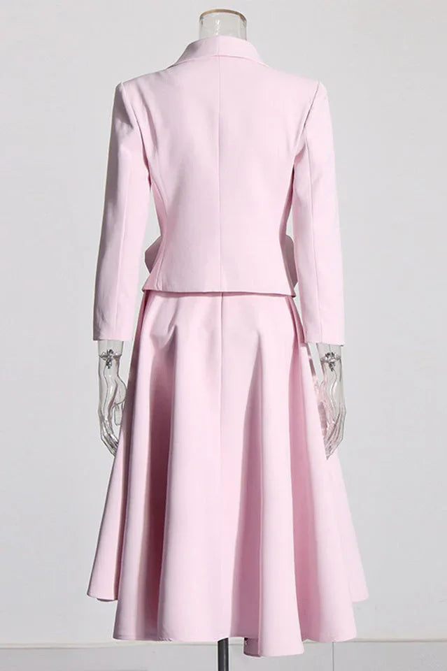 Back view of a pink blazer and skirt set with rose embellishments on a mannequin