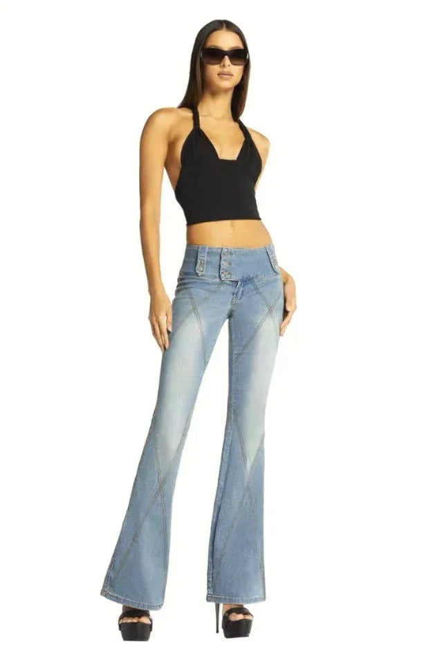 Woman wearing a black halter crop top and light wash flared jeans, with sunglasses.