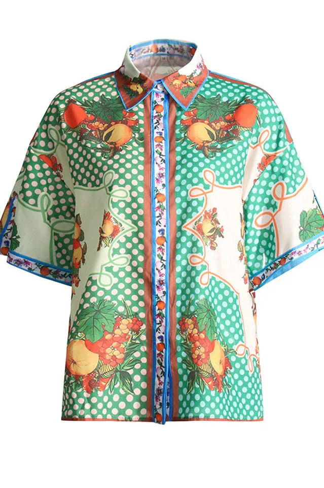 Front view of a fruit print short-sleeve collared shirt with a polka dot pattern.