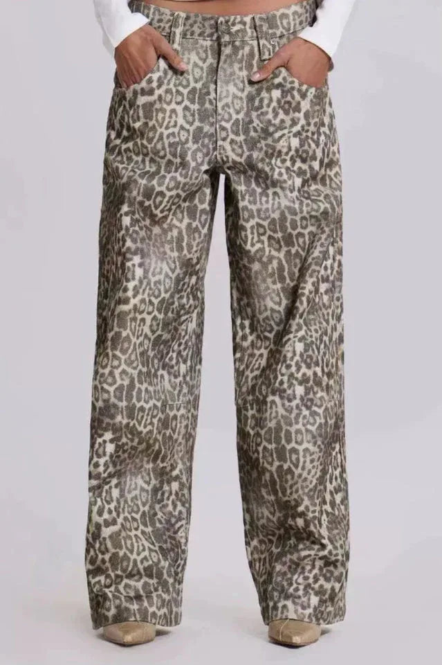 Front view of a model wearing wide leg leopard print denim pants, hands in pockets.