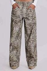 Front view of a model wearing wide leg leopard print denim pants, hands in pockets.