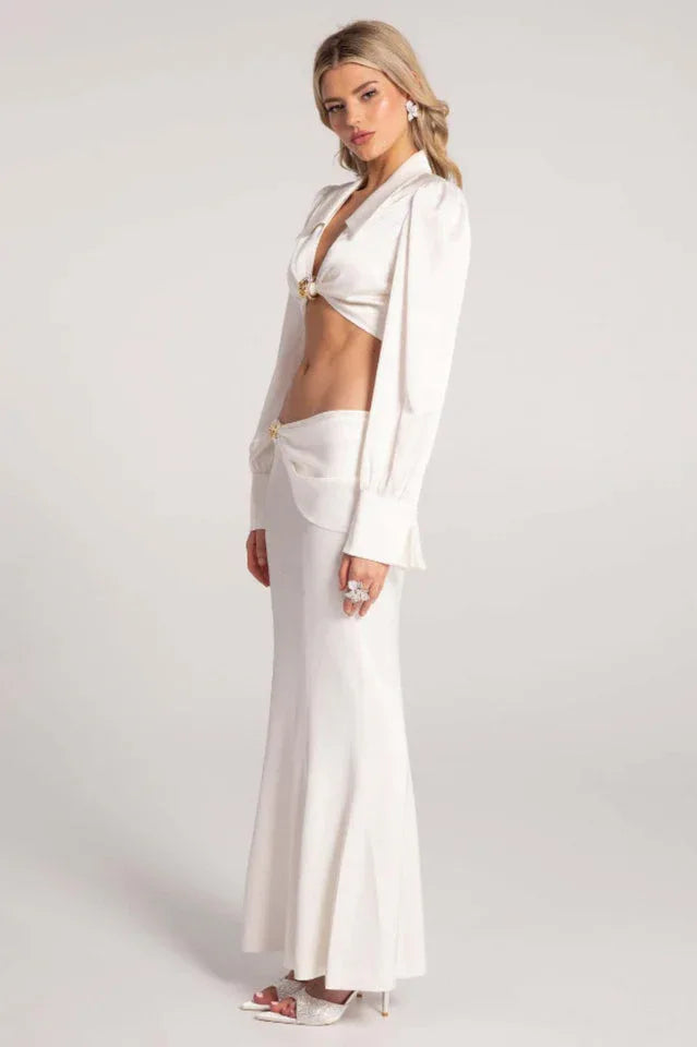 Side view of a woman in a white satin two-piece set.