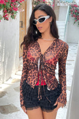 Side profile of a woman in a leopard print sheer mesh top and black ruffled shorts.
