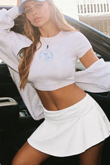 Woman wearing a white crop top and white skort