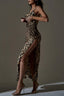 Woman in a leopard print satin maxi dress with a high slit, adjusting the top of the dress.
