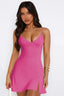 Woman wearing a bright pink sleeveless mini dress with spaghetti straps and a V-neckline, shown from the front.