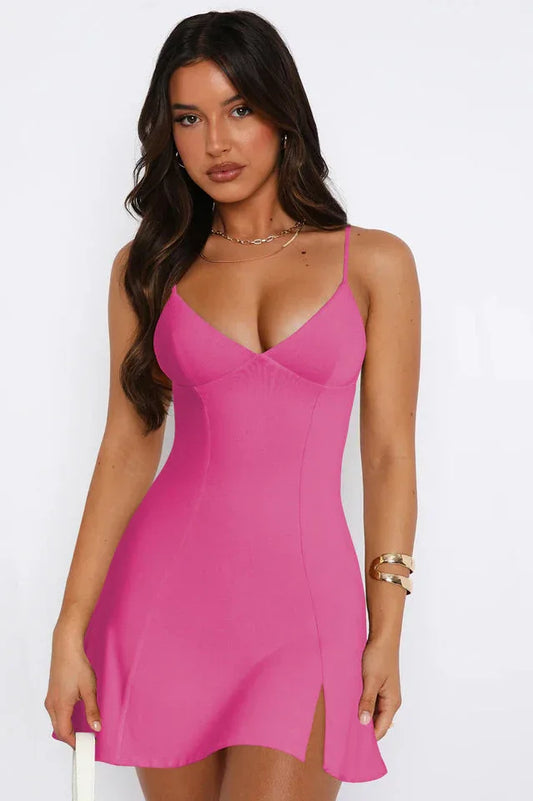 Woman wearing a bright pink sleeveless mini dress with spaghetti straps and a V-neckline, shown from the front.