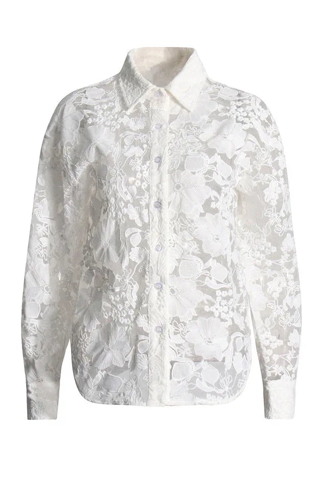 Close-up of a sheer white lace button-down shirt with floral embroidery.