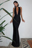Woman in a long black satin halter dress with a deep V-neckline and a flowing skirt.