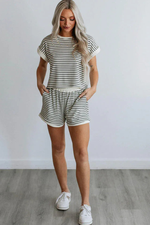 Woman wearing a black and white striped loungewear set, full body front view with sneakers