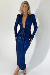 Front view of a woman in an elegant, long-sleeved blue metallic gown with a plunging neckline and a draped skirt.