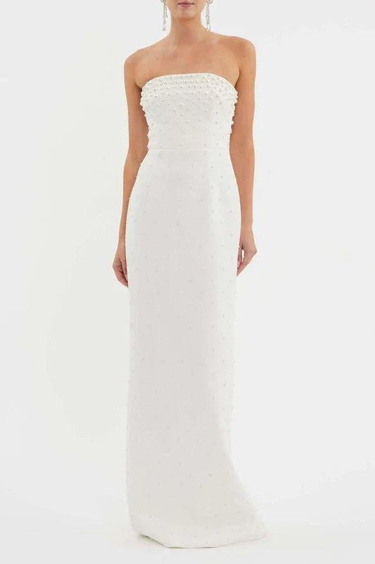 Woman wearing a white strapless pearl-embellished column gown from the front