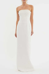 Woman wearing a white strapless pearl-embellished column gown from the front