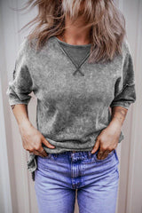 Woman wearing a grey acid wash oversized t-shirt with blue jeans, hands in pockets