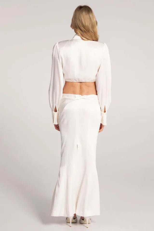 Back view of a woman wearing a white satin two-piece set.