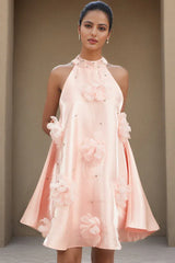 Front view of a woman in a short pink A-line dress with a halter neckline and large floral details.