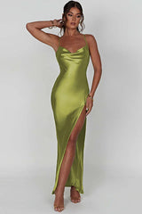 Woman posing with arm raised wearing a long olive green satin slip dress with spaghetti straps and a high slit.