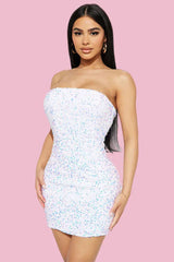 Woman wearing a strapless white sequin mini dress, front view
