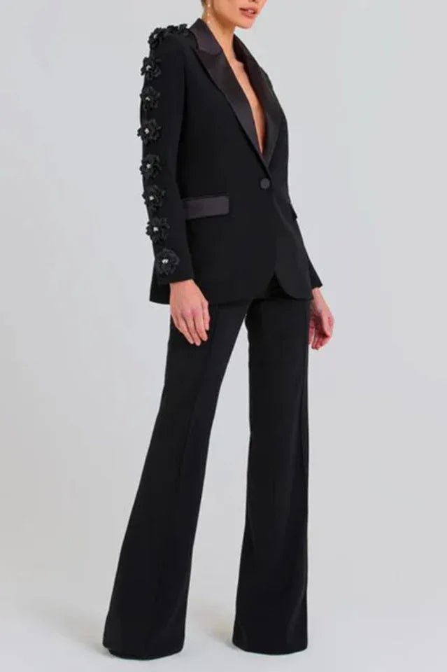 Close-up of a black formal suit jacket with 3D floral embellishments on the sleeves