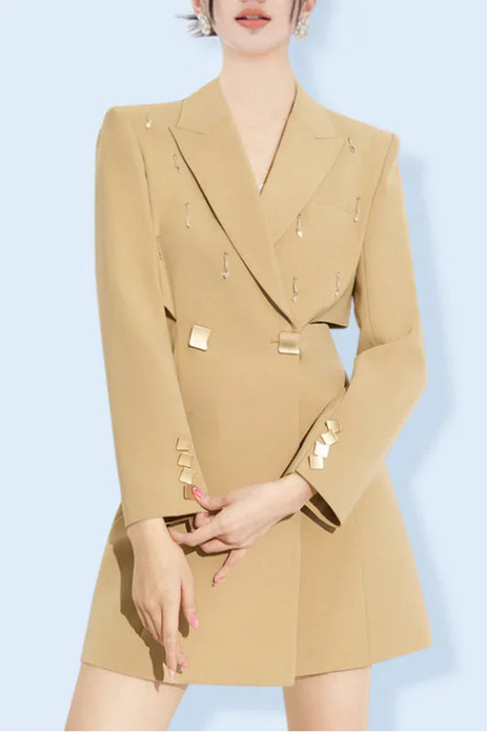 Model wearing a tan double-breasted blazer dress with cut-out details and embellished lapels.