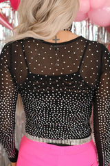 Back view of a woman wearing a black rhinestone mesh bodysuit