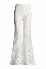 Close-up of white lace flare leg pants with floral embroidery.