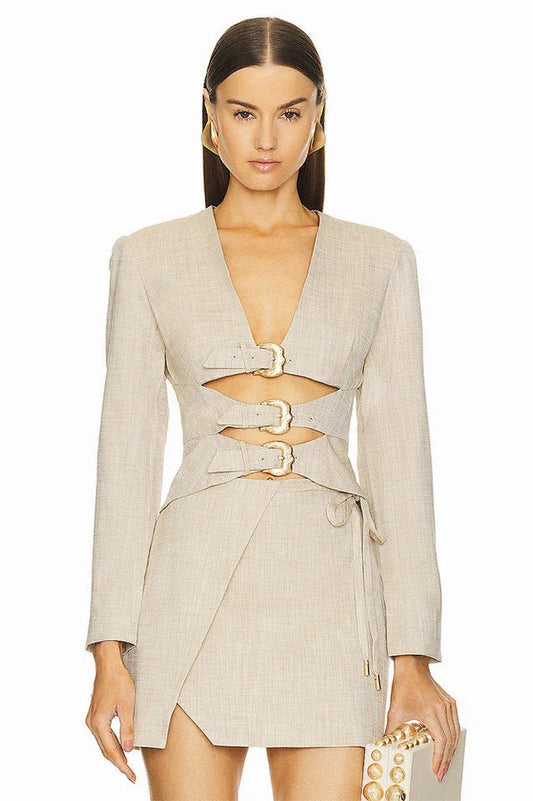 Front view of a beige blazer dress with cut-out details and buckle closures.