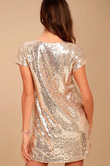 back view of a woman in a gold sequin shift dress