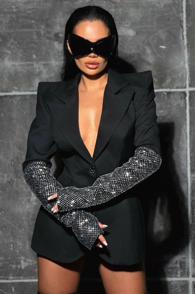 Woman wearing a black blazer with embellished sleeves and sunglasses