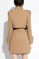 Back view of a woman wearing a beige cropped jacket and matching mini dress, highlighting the jacket's structure and sleeve cuffs