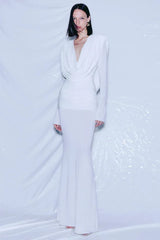 Model wearing a long white draped dress with ruched waist and mermaid hem.