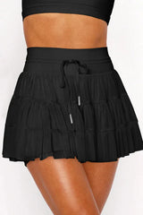 Close-up of the black tiered ruffle skirt showing the drawstring waist and fabric detail.