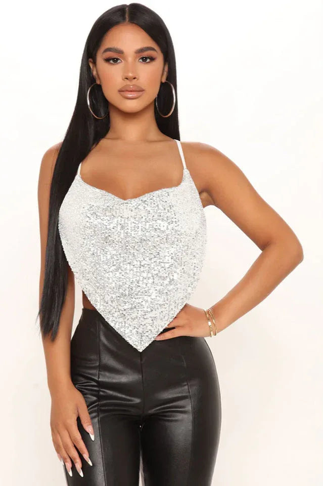 Woman wearing a silver sequined bandana top with black leather pants.
