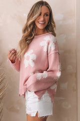 Side view of a woman wearing a pink knit sweater with a flower pattern and pearl embellishments.