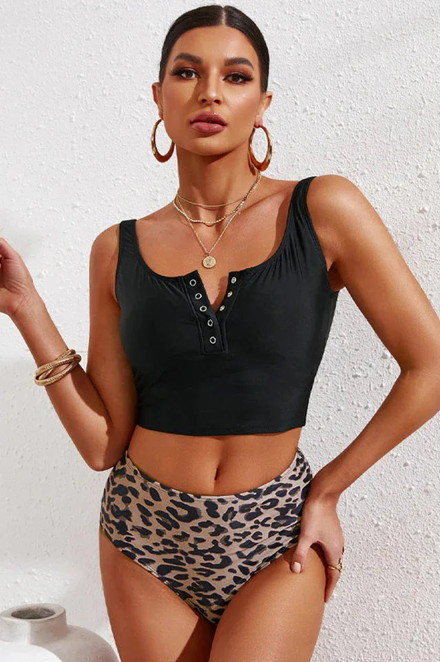 Woman wearing a black cropped tankini top with leopard print high-waisted bottoms