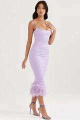 woman in a lavender midi dress with feather trim and spaghetti straps, wearing heels