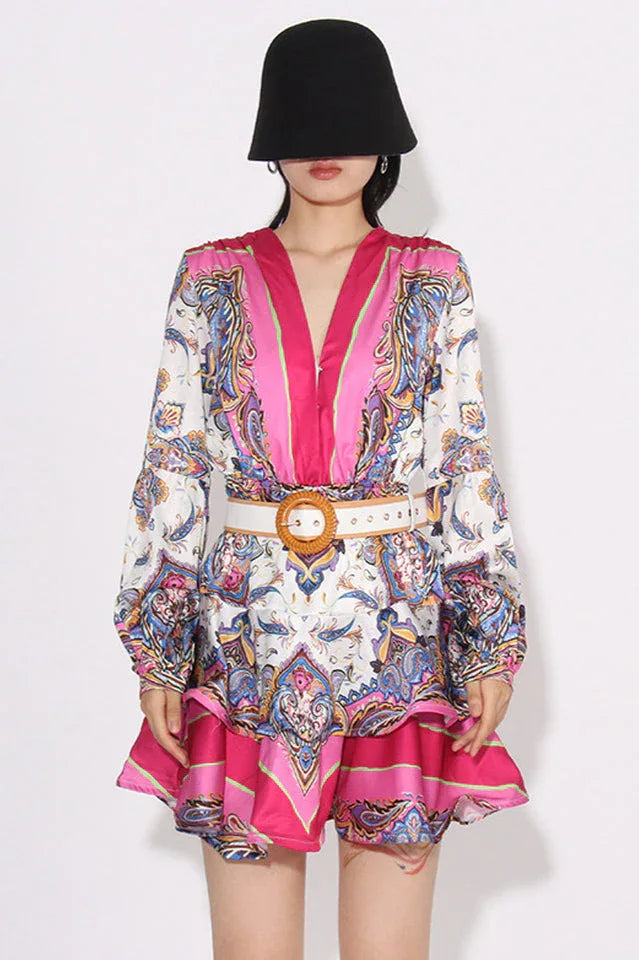 model wearing a paisley print mini dress with a black hat and a belted waist