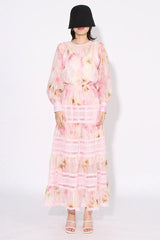Woman wearing a pink floral print maxi dress from the front
