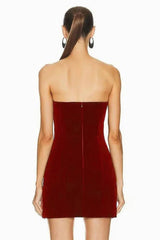 Back view of a burgundy velvet strapless mini dress with a zipper closure.