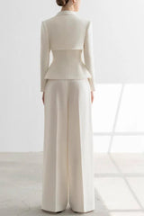 Woman wearing a white tailored suit with a peplum jacket and wide-leg trousers, back view.